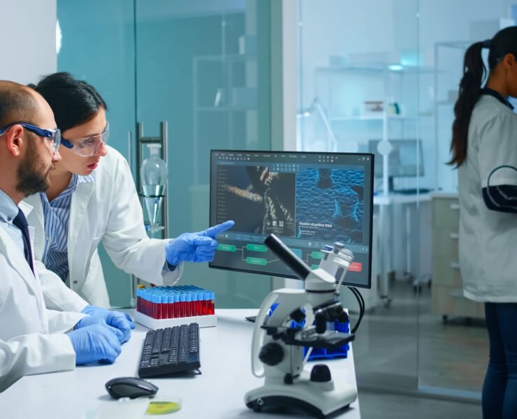 Chemist doctor explaining to coworker vaccine development, DNA mutations working in equipped laboratory. Medical biochemist stuff examining virus evolution using high tech researching diagnosis