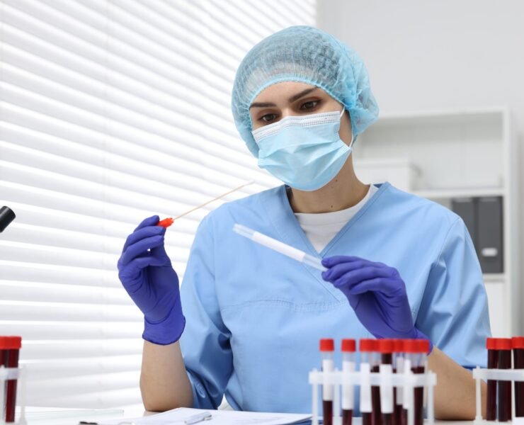 Laboratory testing. Doctor with blood samples in tubes at white table indoors