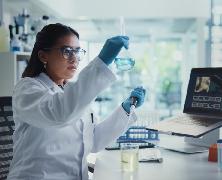 Scientist, woman and beaker with pipette for chemistry, testing and medical research. Biotech, laboratory and analysis with data inspection for pharmaceutical or pathology experiment for breakthrough.